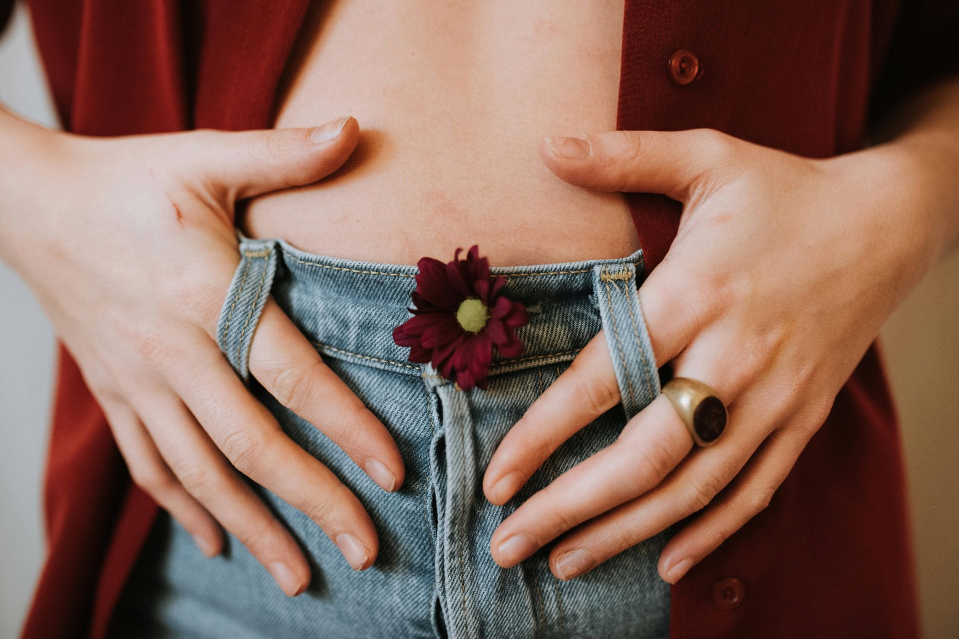 Frau legt ihre Hände auf den Bauch – Symbolbild für Darmsanierung und Darmgesundheit