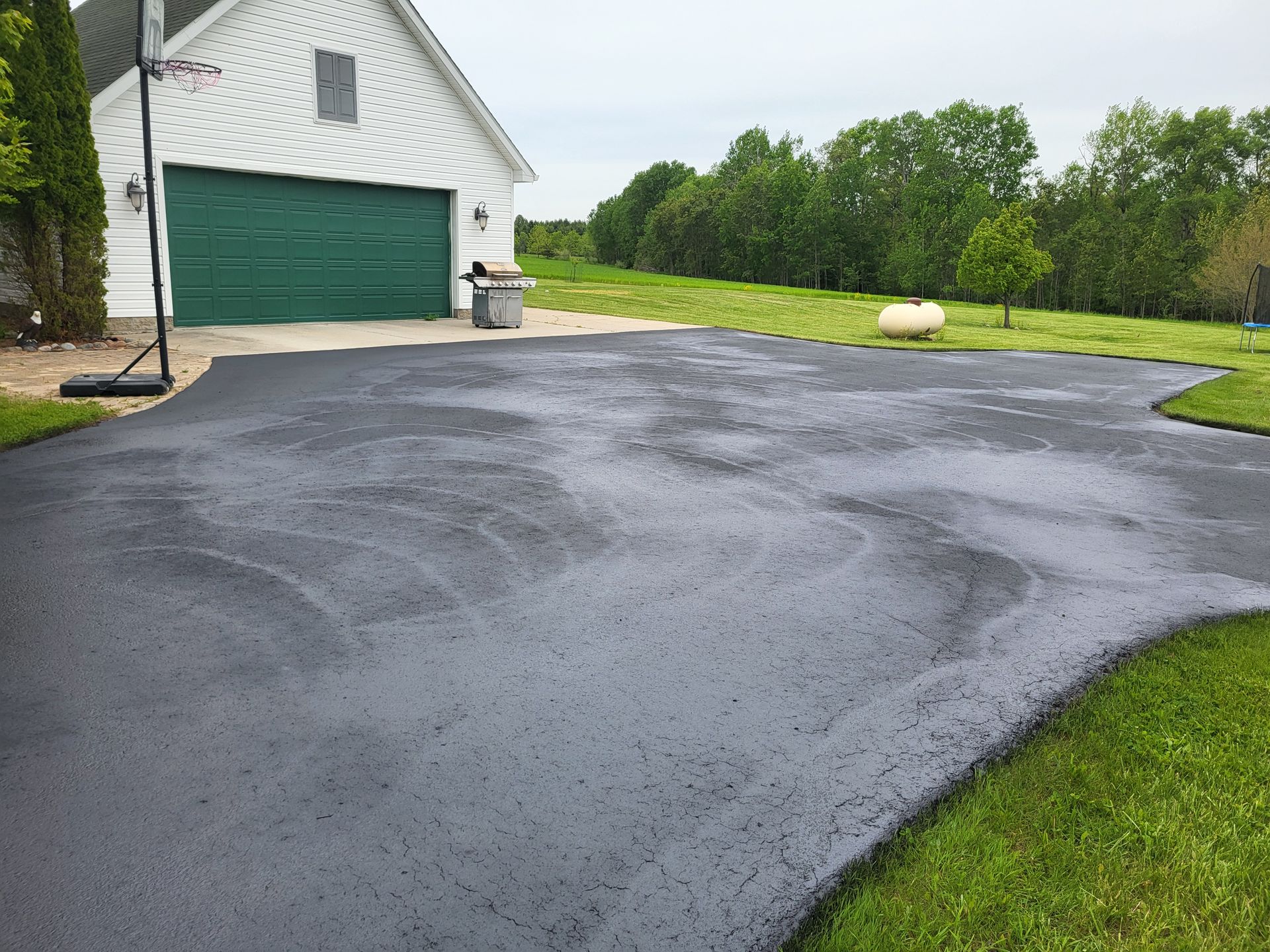 photo of a brick driveway that has been freshly sealed with sealcoating