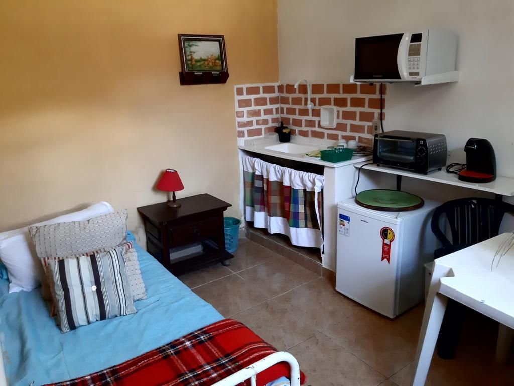 Apartamento tipo casa equipado com frigobar, pia, microondas, banheiro privativo, cama de casal, cama de solteiro, etc.
