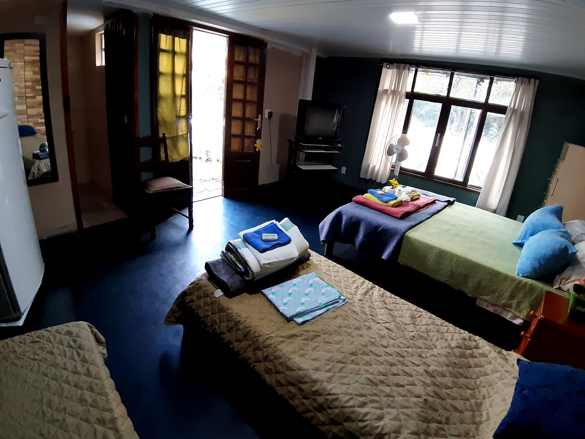 Suíte com 1 cama de casal + 2 camas de solteiro, cômoda, geladeira, banheiro privativo e TV à cabo com mais de 70 canais.