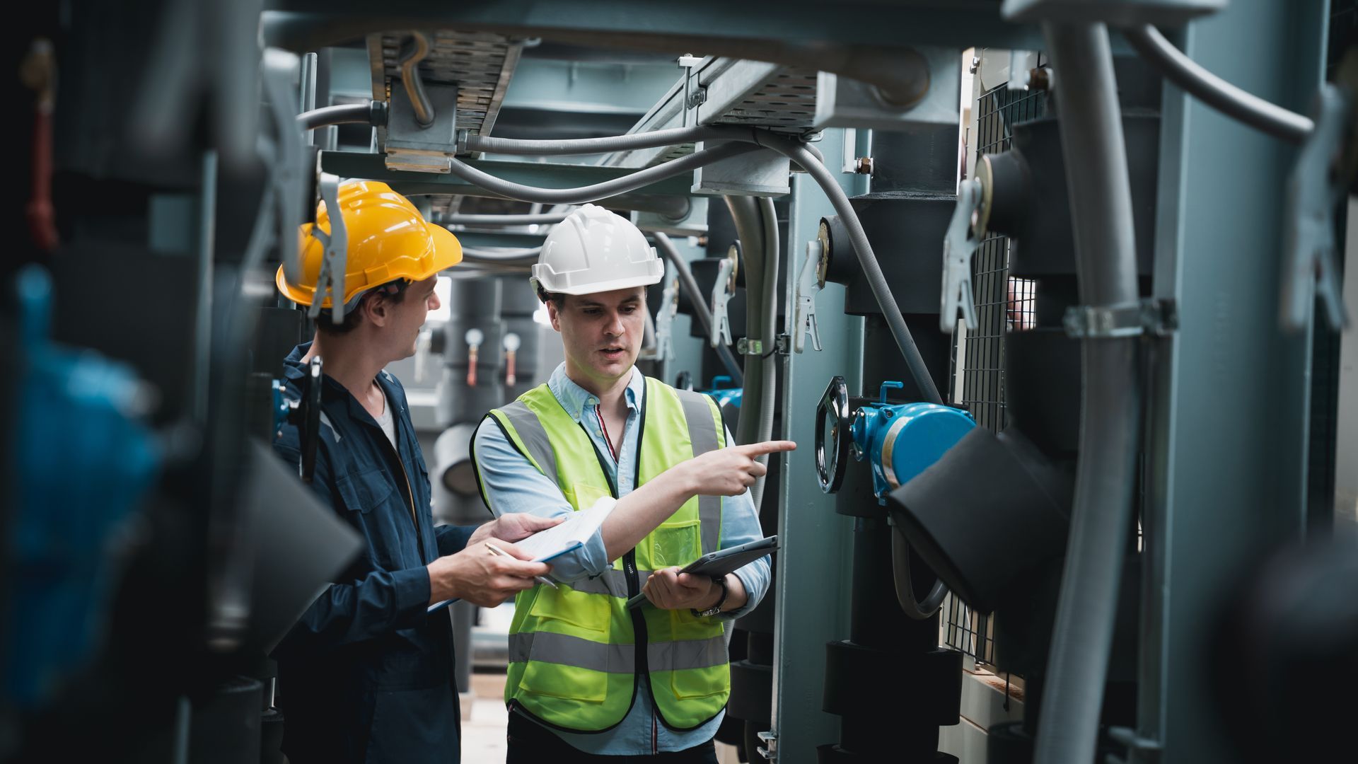 Engineer and team examining the air conditioning cooling system of a huge building or industrial sit