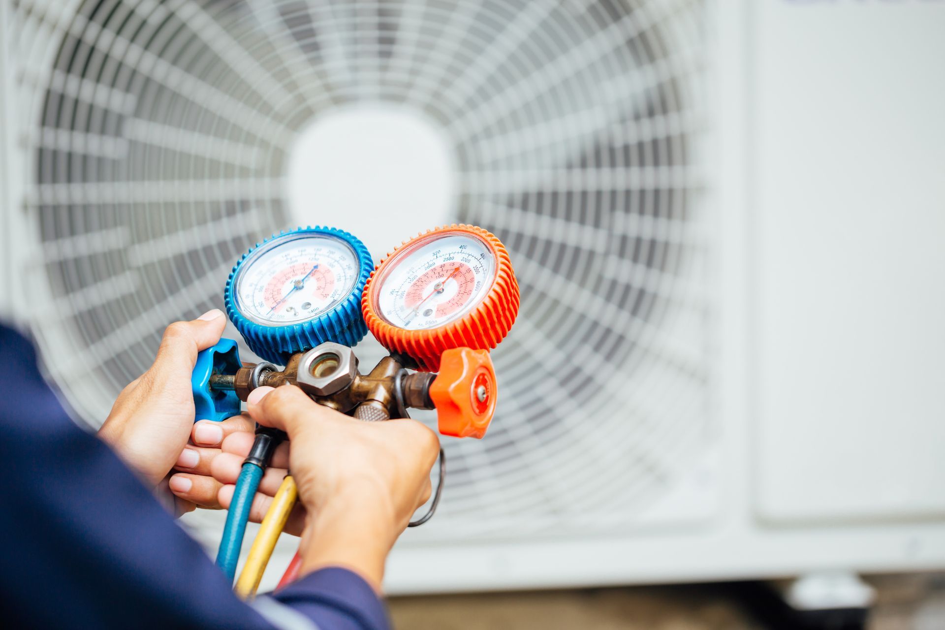 Technician checking HVAC system with pressure gauges for accurate air conditioning service.