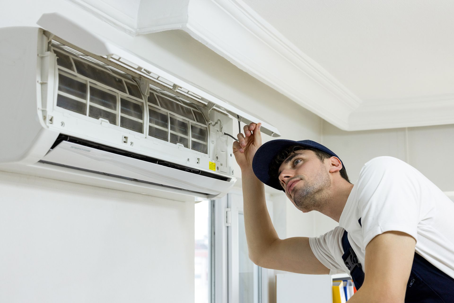 An HVAC technician checking a broken-down split AC unit for repair