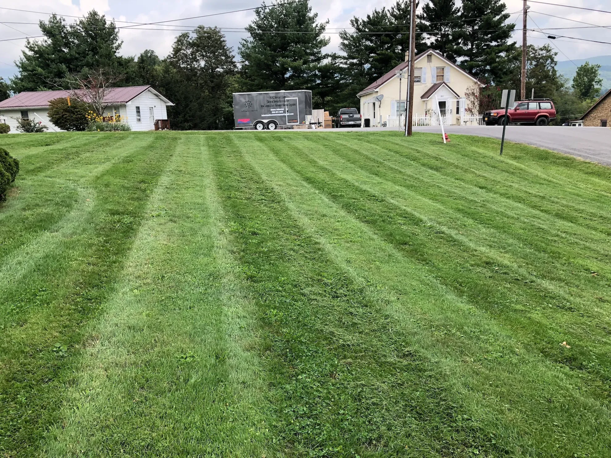 A lush green lawn is being mowed in front of a house.
