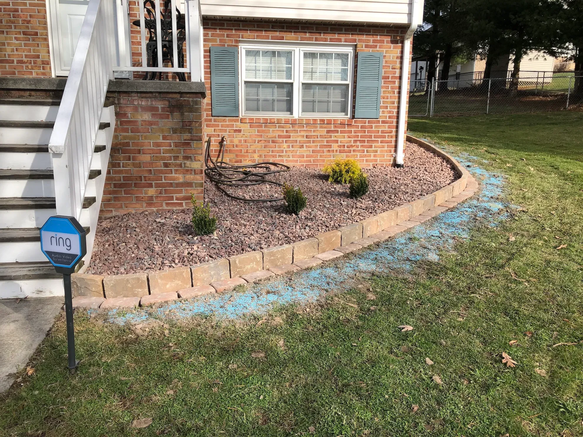 A brick house with stairs and a garden in front of it.