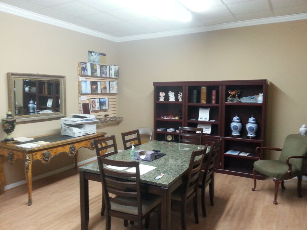 Dining room with a table, chairs, cabinet shelves, wall mirror, and framed decor.