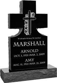 Black cross-shaped gravestone with engraved names Marshall Arnold and Amy, on a stone base