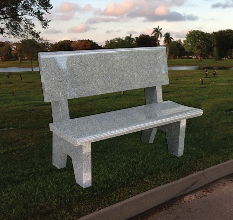 White bench on grass in a park at sunset
