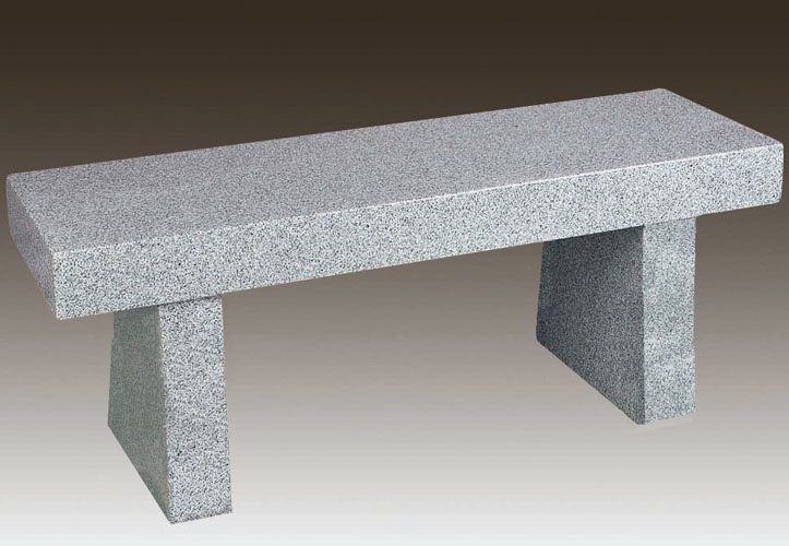 Gray stone bench with two block legs on a plain background