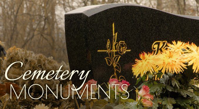 Cemetery monuments with engraved black headstone and yellow flowers on a warm, sepia background