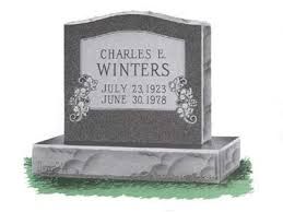 Gray tombstone with engraved name Charles E. Winters and dates, on a stone base.