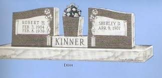 Two headstones with a flower vase and “Kinner” engraved on a marble monument