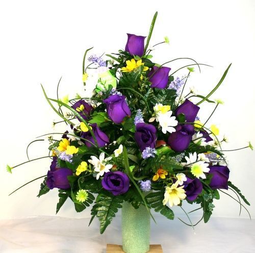Purple and white flower bouquet in a green vase with yellow accents