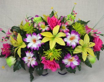 Bright mixed floral arrangement with yellow lilies, pink roses, and white-purple flowers in a basket