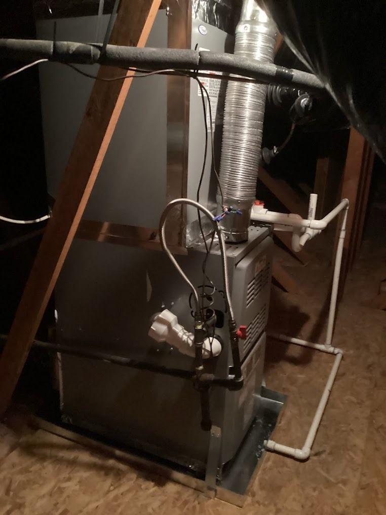 Furnace in a basement with ducts, pipes, and exposed wiring along the unit.