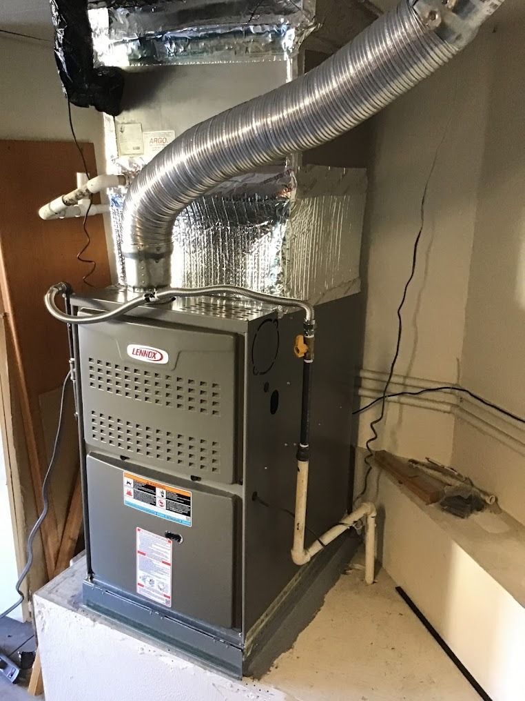 HVAC furnace unit in a utility closet with silver ductwork and exposed wiring nearby