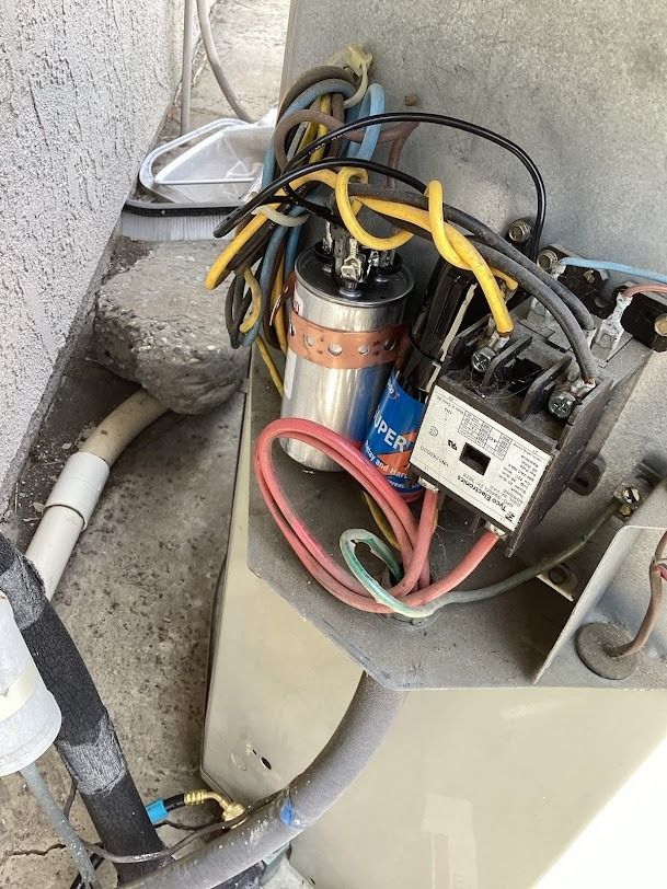 Close-up of an electrical motor and wiring mounted beside a concrete wall.