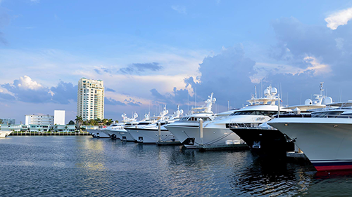 A row of boats are docked in a marina.