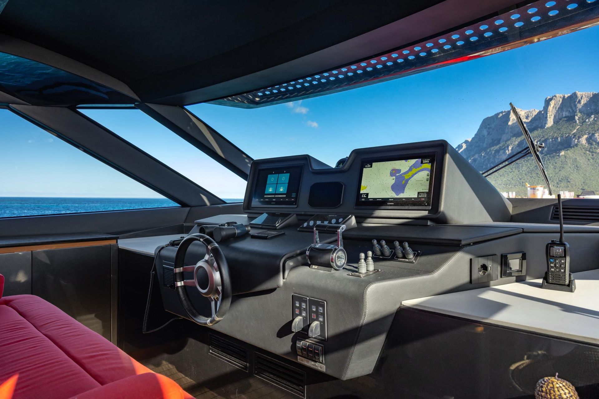 The inside of a boat with a steering wheel and a dashboard.