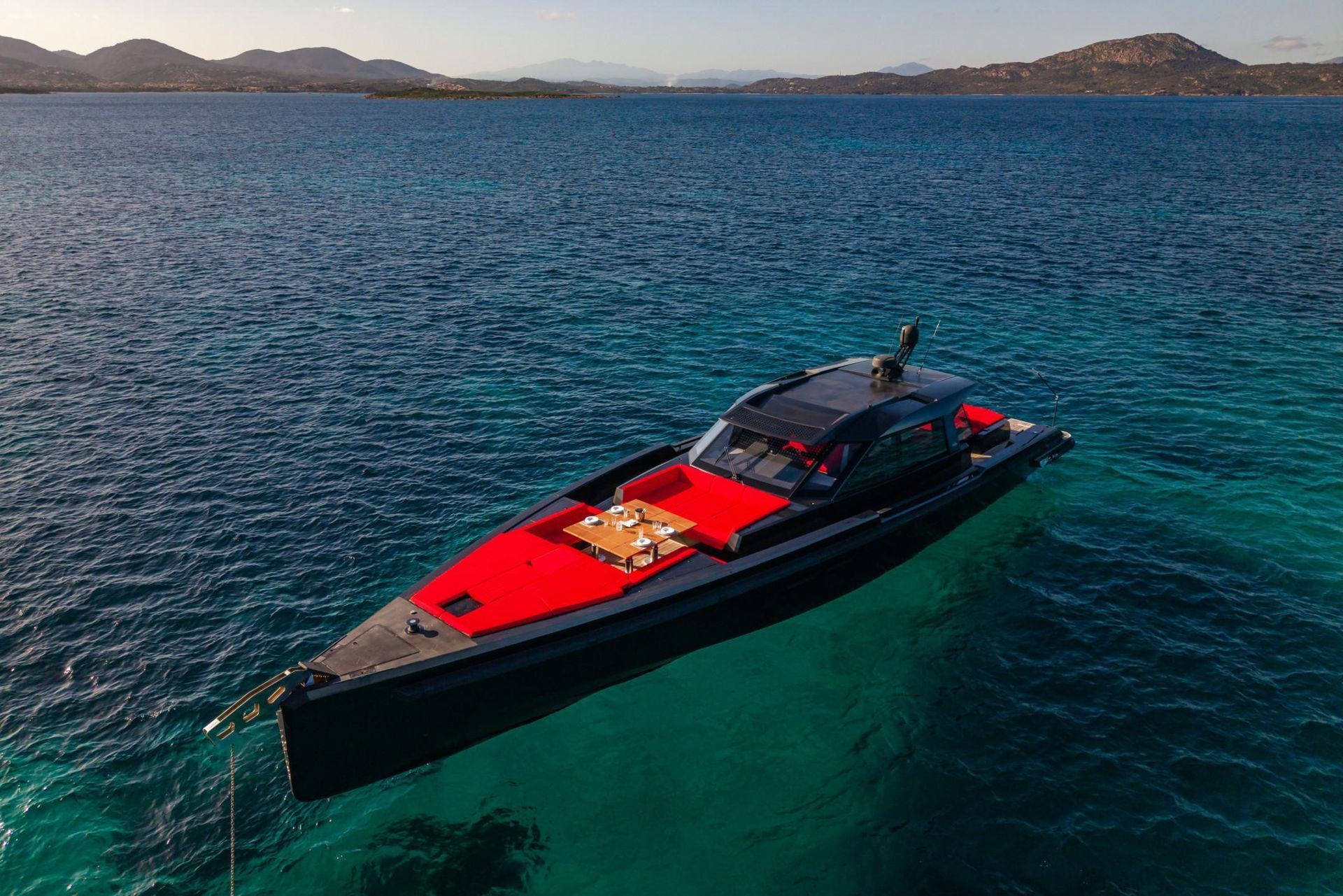 A black and red boat is floating on top of a body of water.