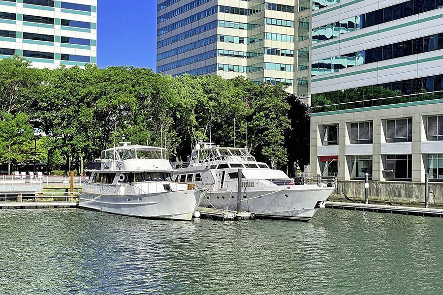 A couple of boats are docked in a harbor with buildings in the background.