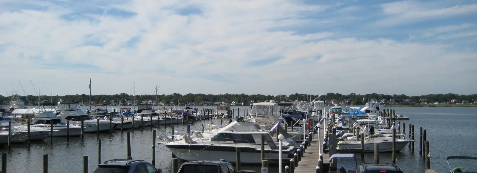Many boats are docked at a marina on a sunny day