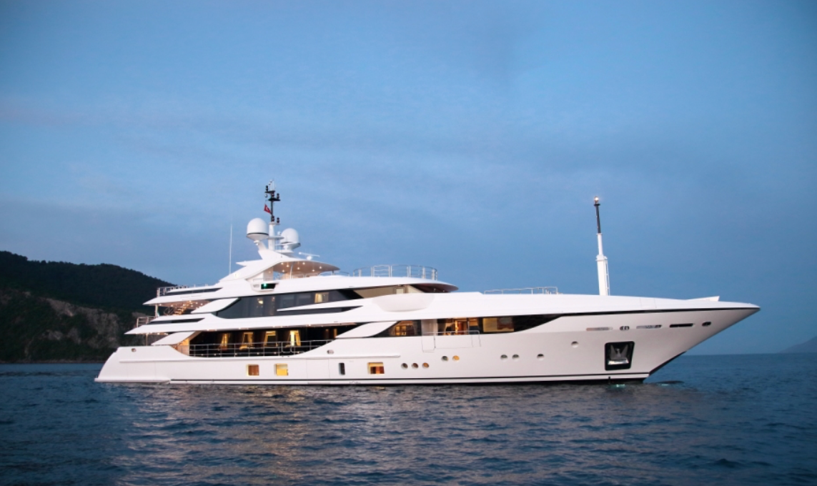 A large white yacht is floating on top of a body of water.