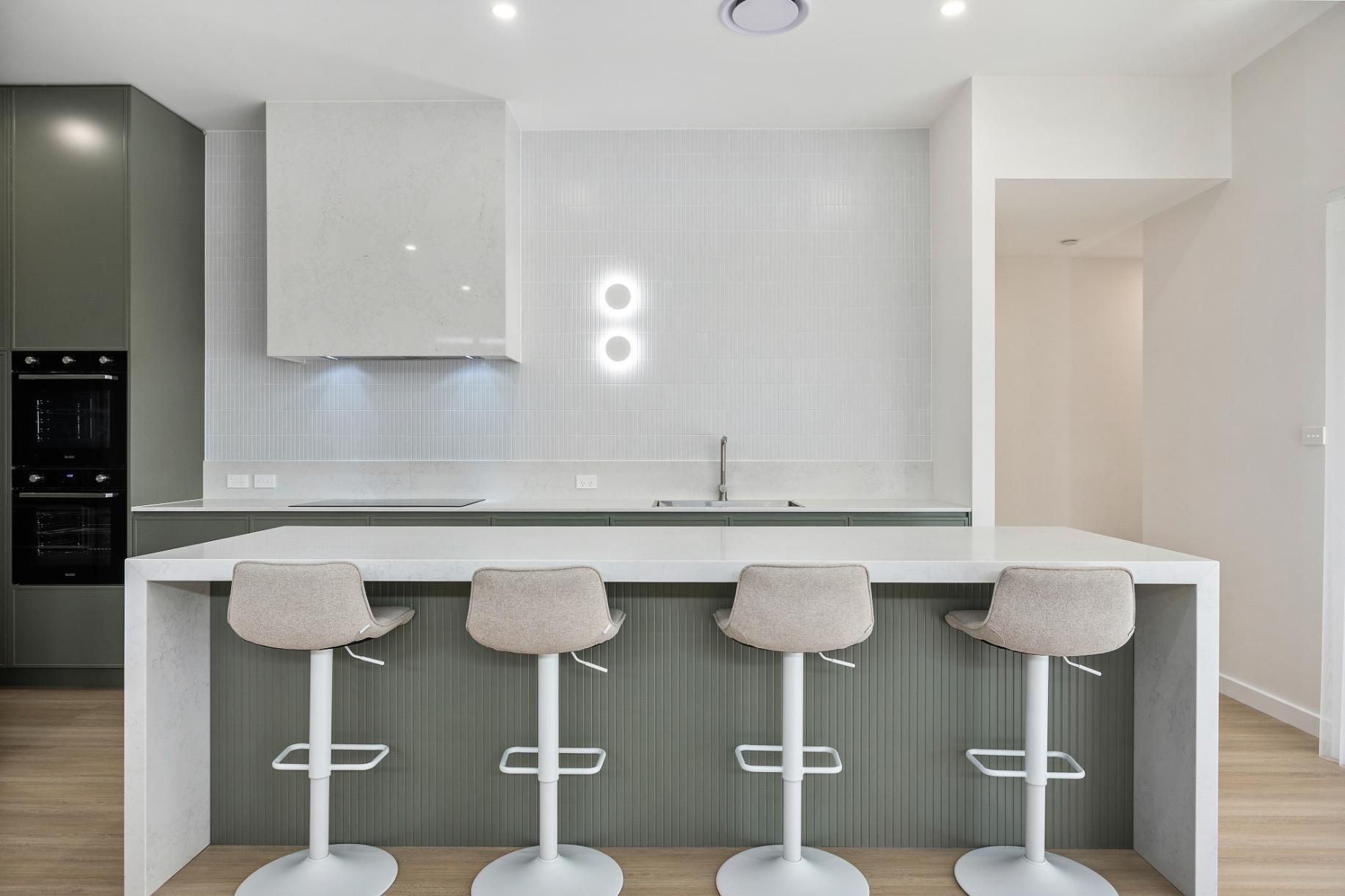 Four stools are tucked under a kitchen bench — Darko's Kitchens in Albion Park Rail, NSW