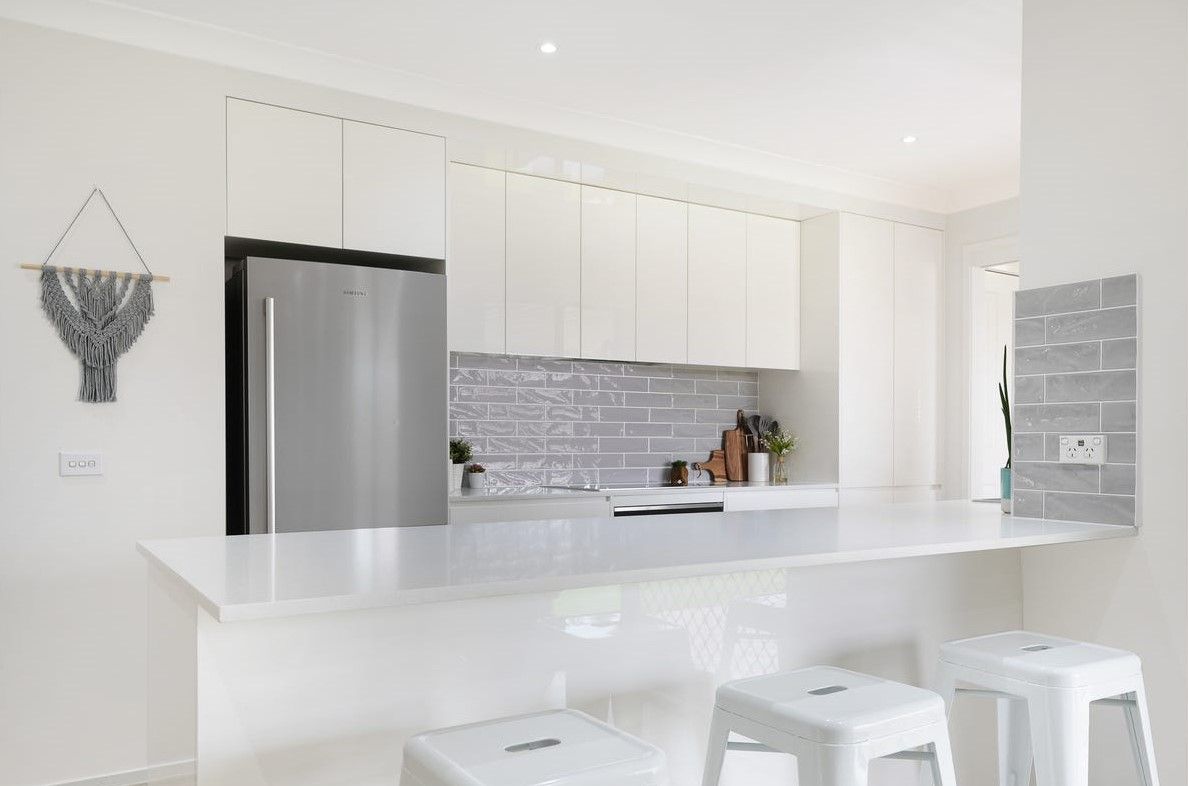 A Kitchen With White Cabinets and white stools — Darko's Kitchens in Albion Park, NSW