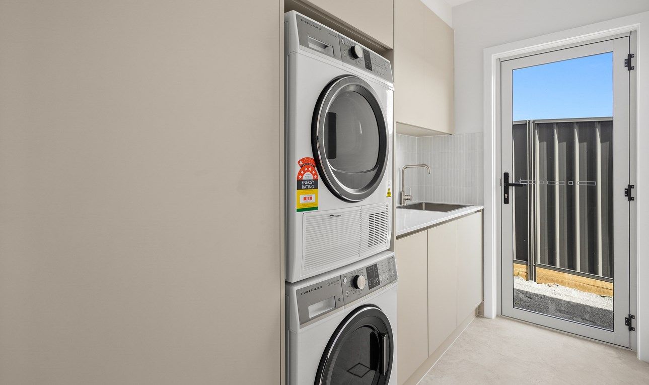 A Washer and Dryer Are Stacked on Top of Each Other in a Laundry Room — Darko's Kitchens in Albion Park Rail, NSW