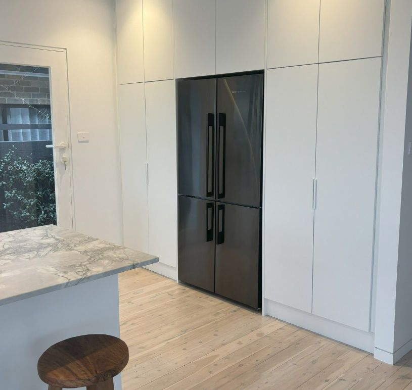 A Kitchen With White Cabinets and a Stainless Steel Refrigerator — Darko's Kitchens in Albion Park, NSW