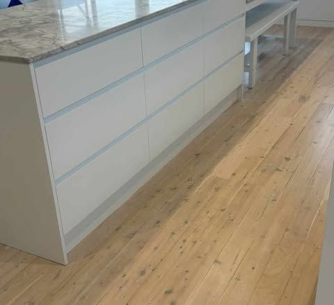 A Kitchen With a Wooden Floor and White Cabinets — Darko's Kitchens in Albion Park Rail, NSW