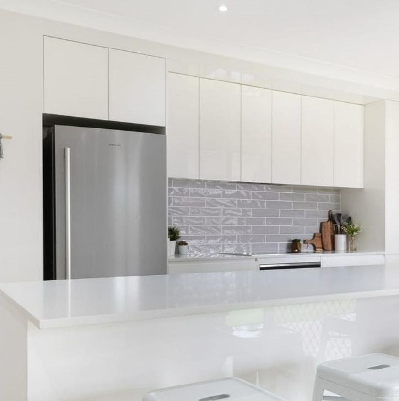A Kitchen With White Cabinets and a Stainless Steel Refrigerator — Darko's Kitchens in Dapto, NSW