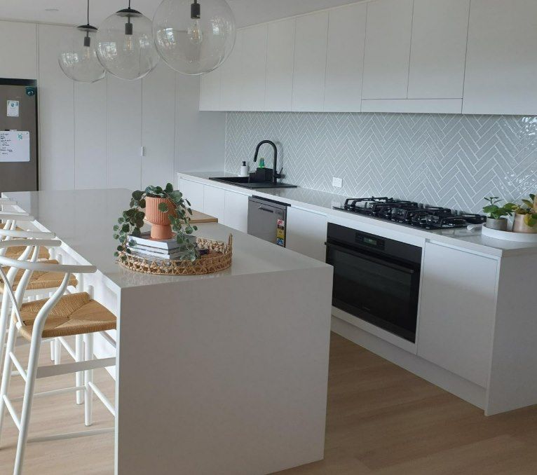 A Kitchen With White Cabinets and a Stove Top Oven — Darko's Kitchens in Kiama, NSW