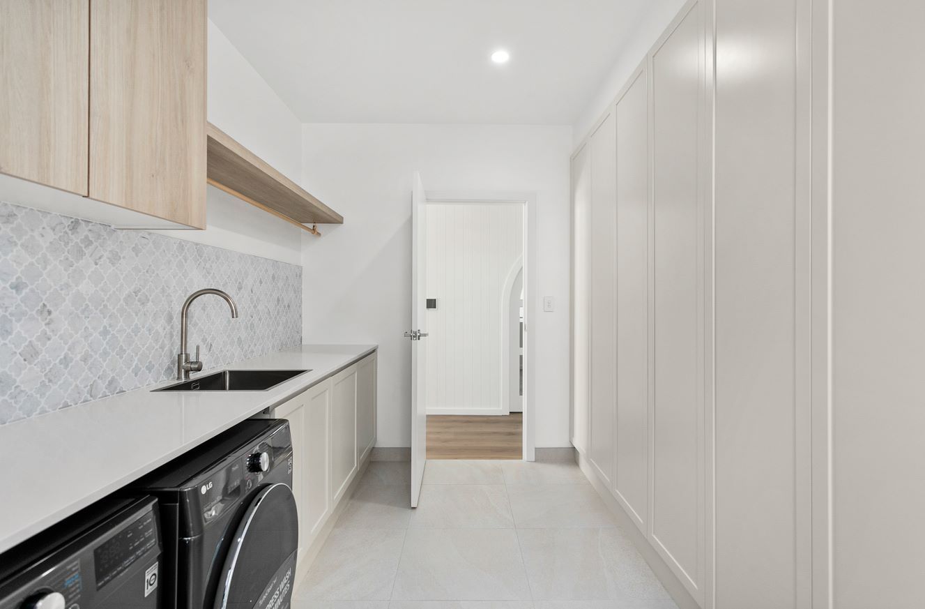 A Laundry Room With a Washer and Dryer , Sink , and Cabinets — Darko's Kitchens in Albion Park Rail, NSW