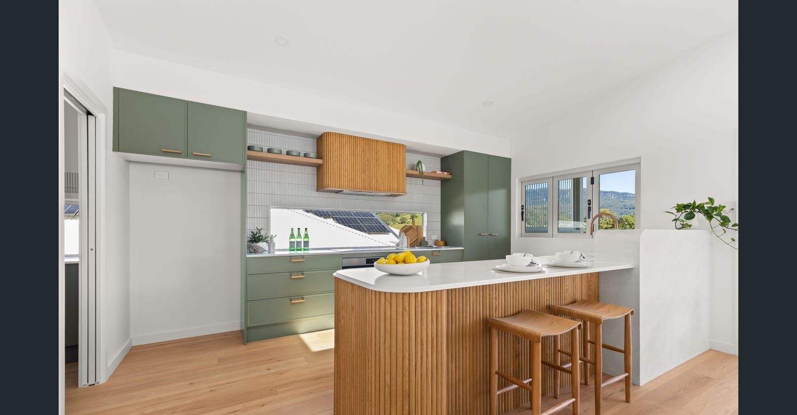 A Kitchen Featuring Wooden Floors and Green Cabinets, Creating a Warm and Inviting Atmosphere — Darko's Kitchens in Calderwood, NSW