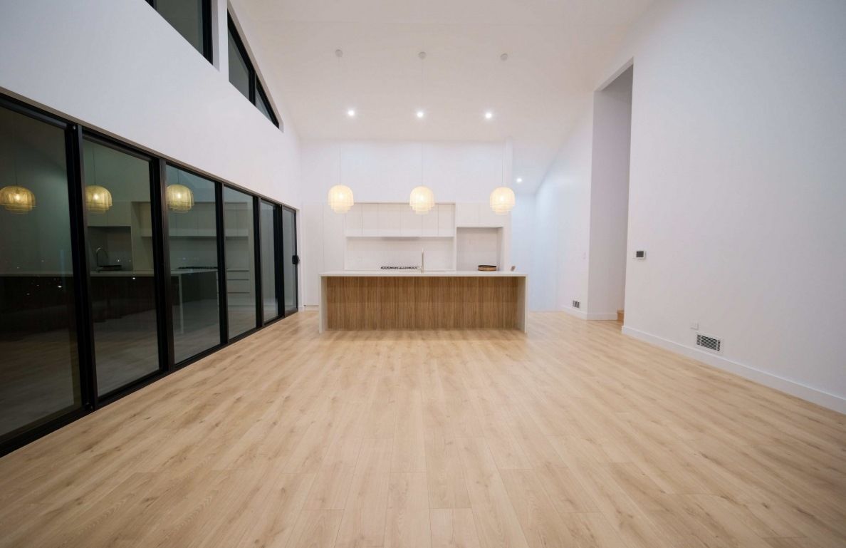 A Spacious Kitchen Featuring A Large White Island with Light Wood Drawers — Darko's Kitchens in Blackbutt, NSW