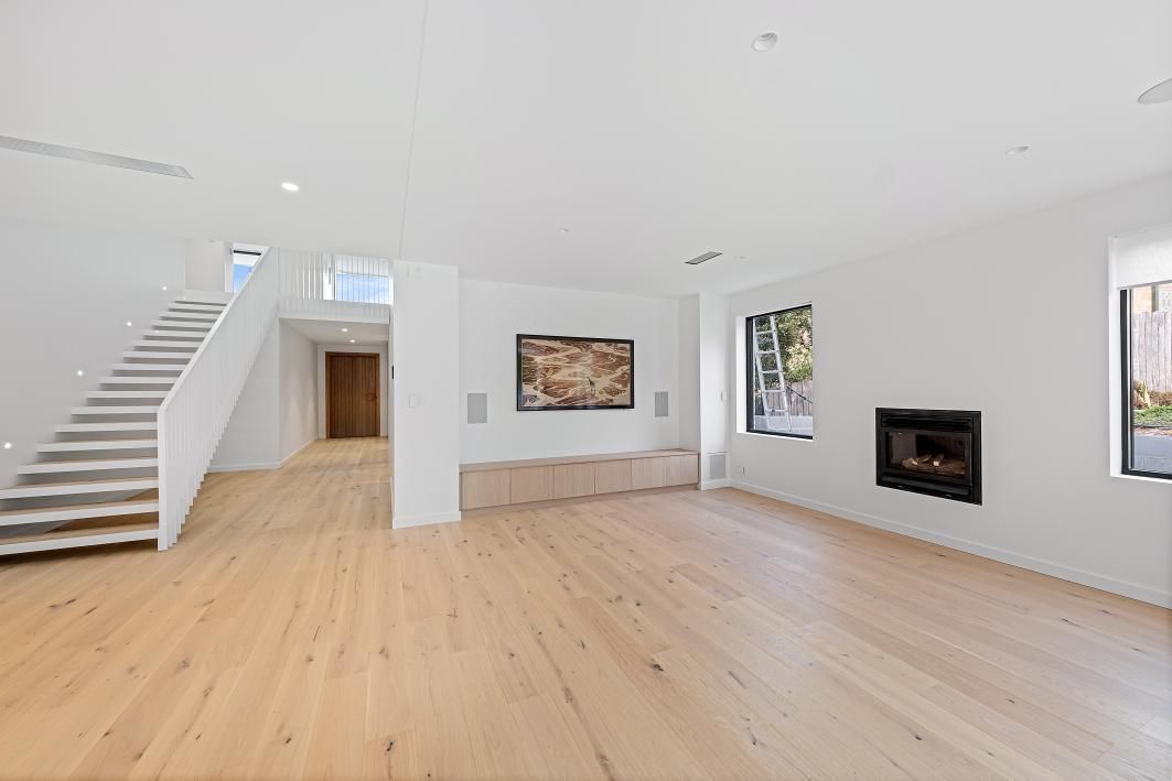 Spacious Modern Living Room With Light Wood Flooring, White Walls, and a Recessed Fireplace — Darko's Kitchens in Woonona, NSW