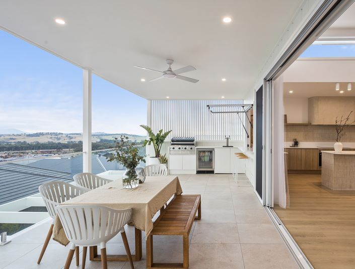 There is a Table and Chairs on the Balcony With a View of the Ocean — Darko's Kitchens in Albion Park Rail, NSW