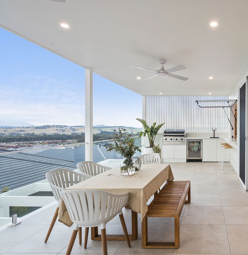 A Table and Chairs on a Balcony Overlooking a Body of Water — Darko's Kitchens in Albion Park Rail, NSW