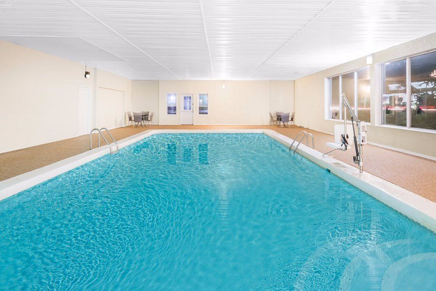 Indoor rectangular swimming pool with clear blue water and beige walls.