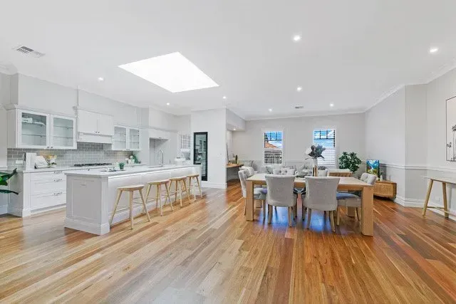 Bright Open-Plan Kitchen and Dining Room with White Cabinets, Wood Floors — Boyne Building & Renovations in Ponto, NSW