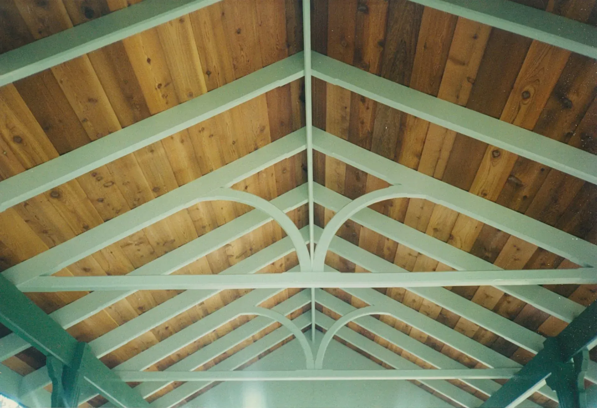 Wooden Roof Trusses with Teal Beams Forming a Symmetrical Ceiling — Boyne Building & Renovations in Ponto, NSW