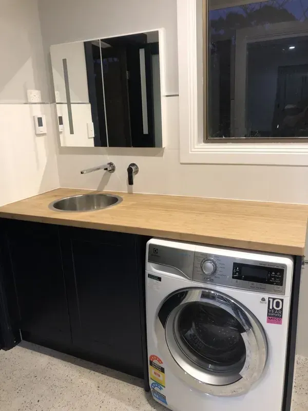 Laundry Room with Black Cabinets, Wood Countertop, Sink, Mirror — Boyne Building & Renovations in Ponto, NSW