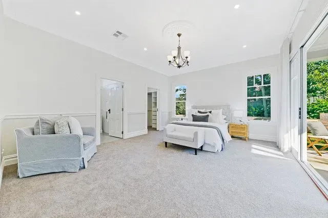Bright dining area with white table and chairs, brick accent wall, and sliding glass doors opening to a patio.