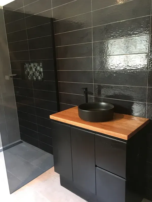 Modern Black Bathroom with Wall Tiles, Wooden Countertop — Boyne Building & Renovations in Ponto, NSW
