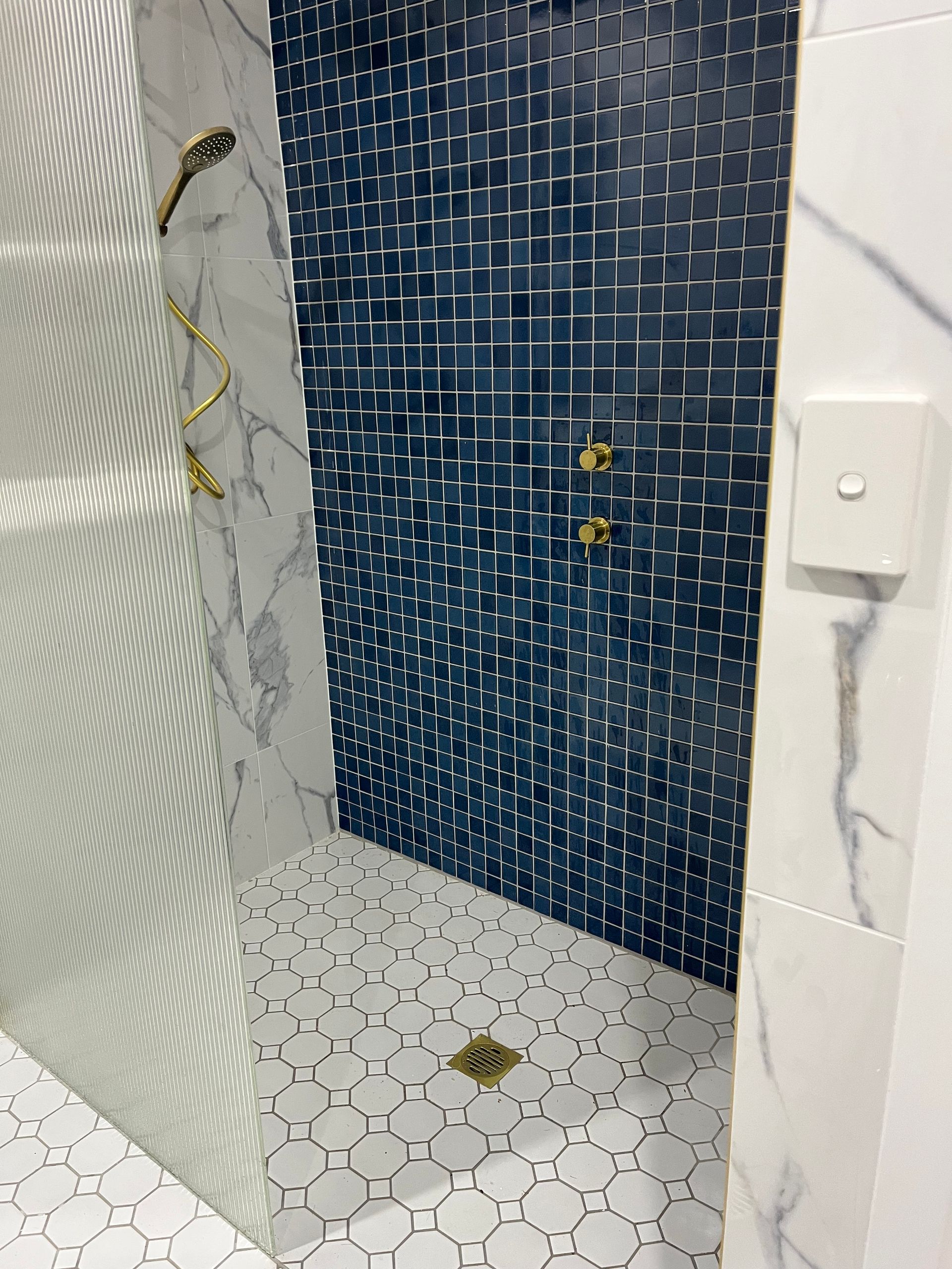 Shower With Blue Mosaic Wall and White Hex Tile Floor — Boyne Building & Renovations in Ponto, NSW