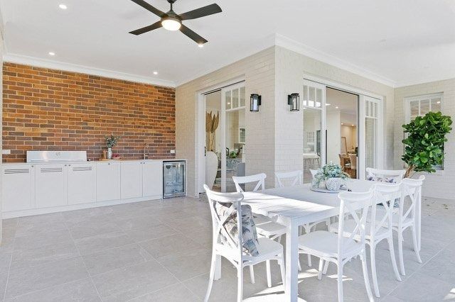 Modern Patio with White Dining Set, Brick Accent Wall — Boyne Building & Renovations in Ponto, NSW