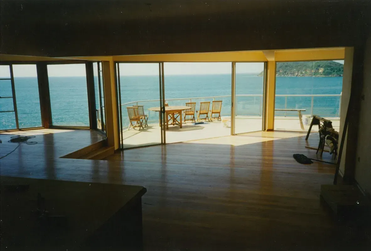 Beachfront Interior with Wooden Floor, Open Sliding Doors — Boyne Building & Renovations in Ponto, NSW