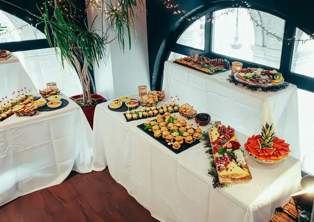 Buffet table with assorted appetizers and fruit platters in a bright dining room